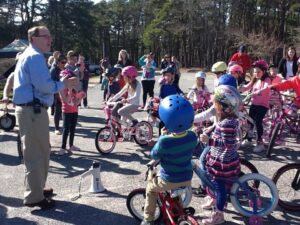 Children gathered on bicycles with helmets, ready for a ride.