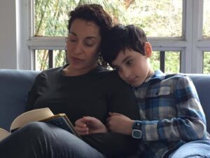 Woman reading aloud to her son on a couch