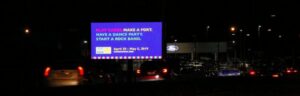A billboard advertising Fort Wayne's 2023 Summer Concert Series at night.