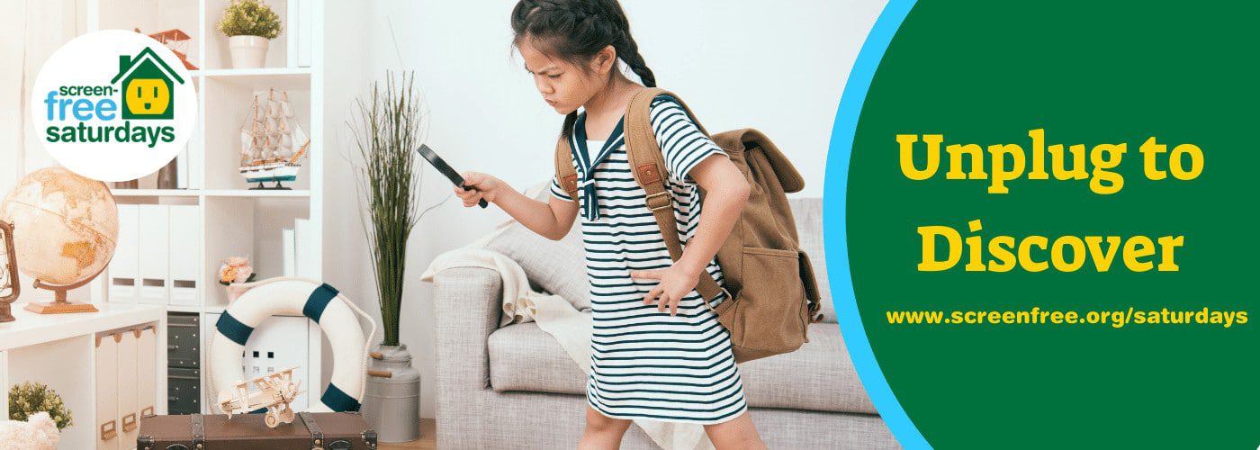 Girl exploring with magnifying glass indoors.