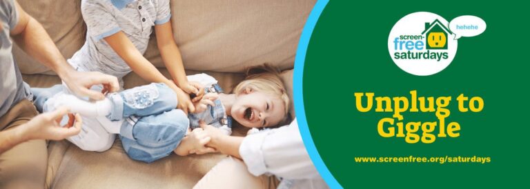 Family tickling child on a couch, laughing.