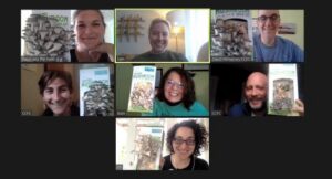 Six people smiling and holding books during a virtual meeting.