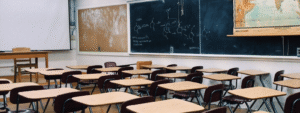 Empty classroom with desks and chalkboards filled with scientific diagrams.