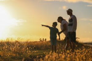 A family enjoying a sunset walk in a field.