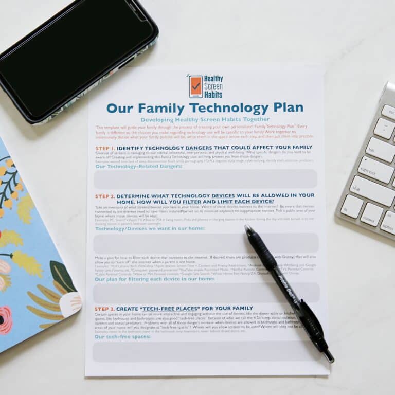 A document titled 'Our Family Technology Plan' on a desk with a pen, phone, and keyboard.