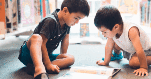 Two children focused on a board game indoors.