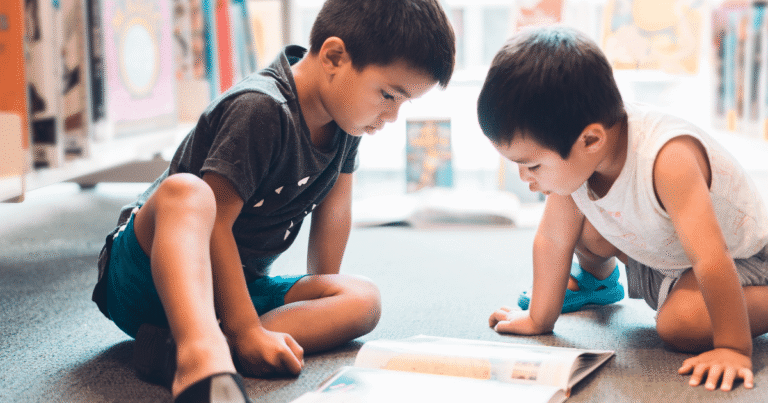 Two children focused on a board game indoors.