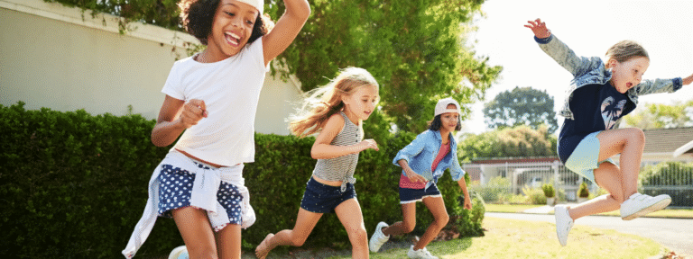 Children happily running outdoors on a sunny day.